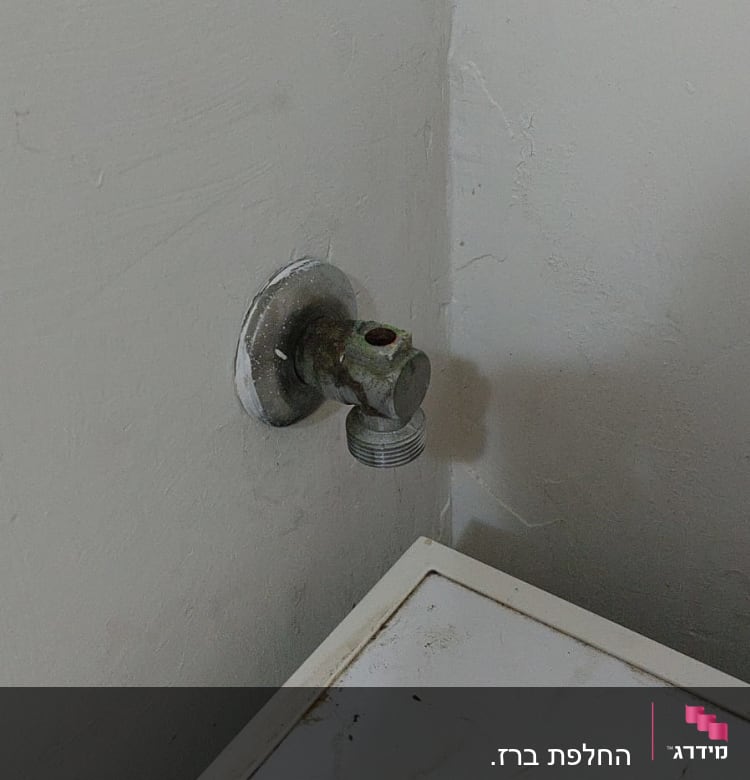 ברז מים מתכת מחובר לקיר עם חלודה